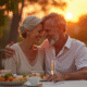 Couple mature souriant lors d'un dîner en plein air au coucher du soleil